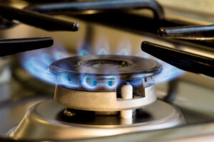 A gas stove with blue flames burning brightly in a kitchen