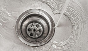 A Sink With Water Flowing Down The Drain. Drain Cleaning, Clear Drains, Clogs