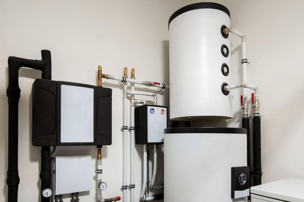 A white water heater beside a black water heater both displaying compact designs suitable for residential use