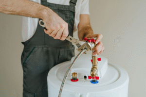 A man is engaged in fixing a water heater surrounded by tools and equipment in a home setting