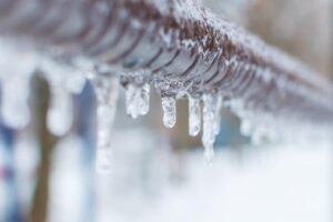 Long icicles dangling from a fence showcasing a frosty winter atmosphere