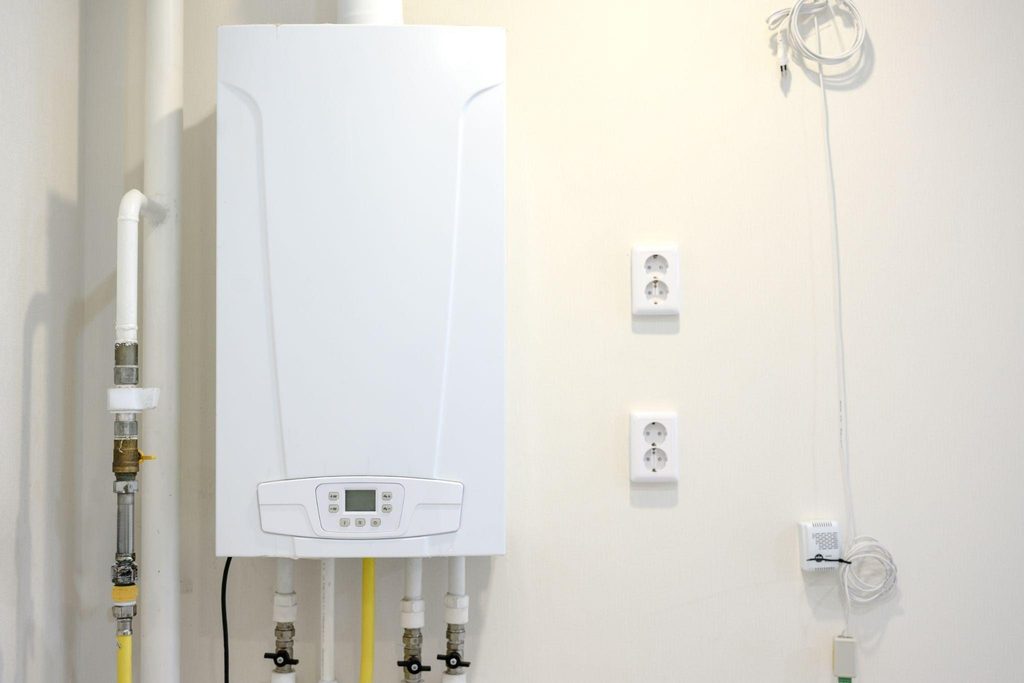 A gas boiler mounted on a wall featuring a digital display and control panel for temperature settings